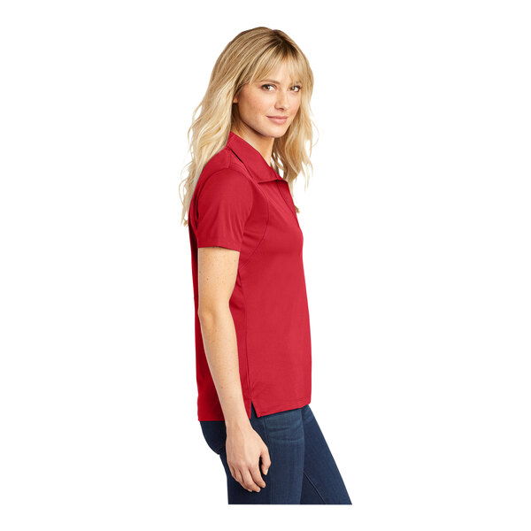 A woman wearing a Sport-Tek True Red polo shirt.