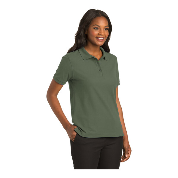 A woman wearing a Port Authority clover green polo shirt.