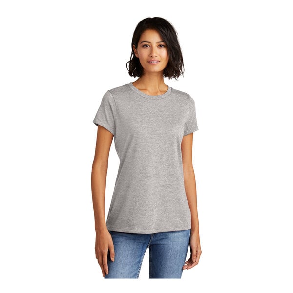 A woman wearing a light heather grey District scoop neck t-shirt.