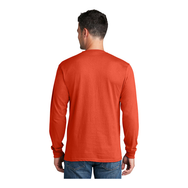 A man wearing an extra large orange Port & Company long sleeve T-shirt.
