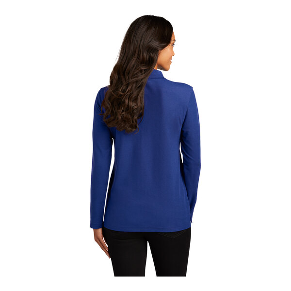 A woman with long hair wearing a royal blue Port Authority long sleeve polo shirt.