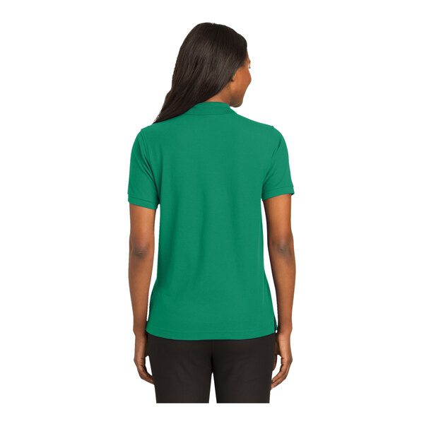 A woman wearing a Port Authority Kelly green polo shirt.