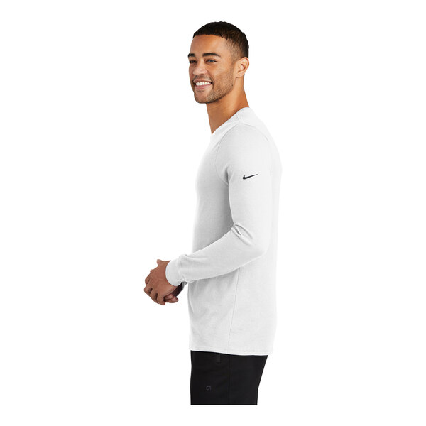 A man wearing a white Nike Dri-FIT long sleeve T-shirt.