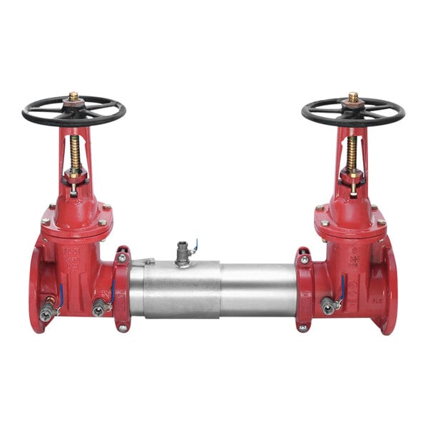 A red and silver Watts backflow preventer with black wheels on the valves.