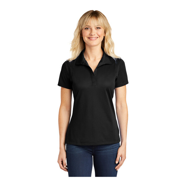 A woman wearing a black polyester Sport-Tek short sleeve polo shirt.