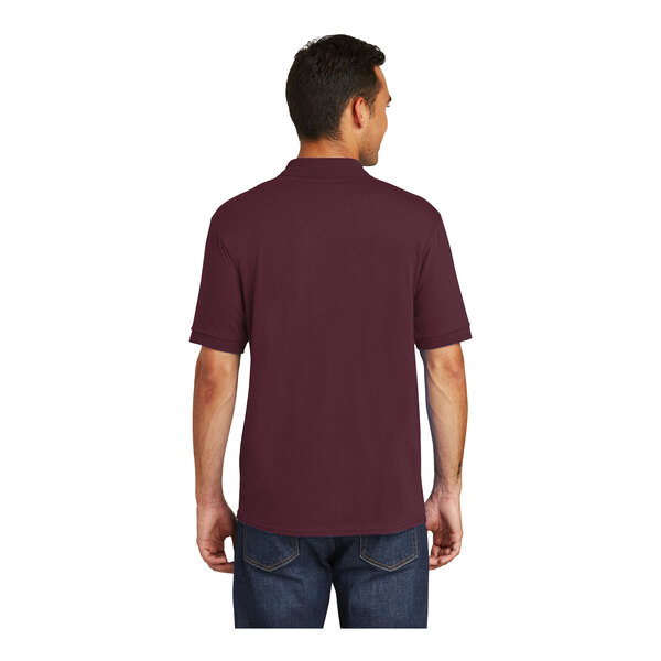 A man wearing a maroon Port & Company jersey knit polo shirt.