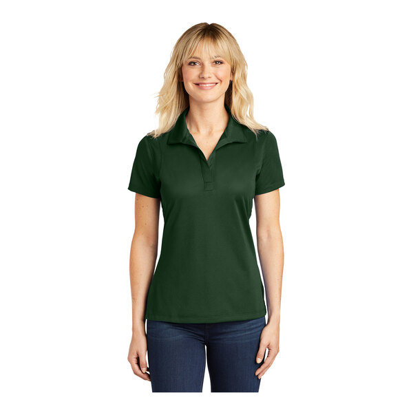 A woman wearing a Sport-Tek forest green short sleeve polo shirt.