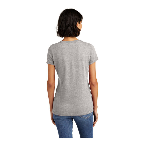 A woman wearing a light heather grey District short sleeve T-shirt.