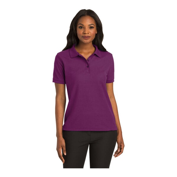 A woman wearing a deep berry Port Authority polo shirt.