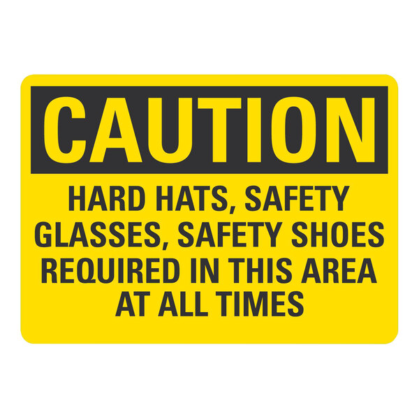 A yellow and black rectangular plastic safety sign with the message "Caution Hard Hats, Safety Glasses, Safety Shoes Required In This Area"