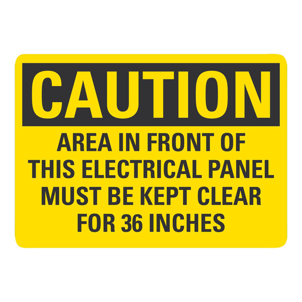 A yellow and black rectangular plastic sign that says "Caution / Area In Front Of This Electrical Panel Must Be Clear"