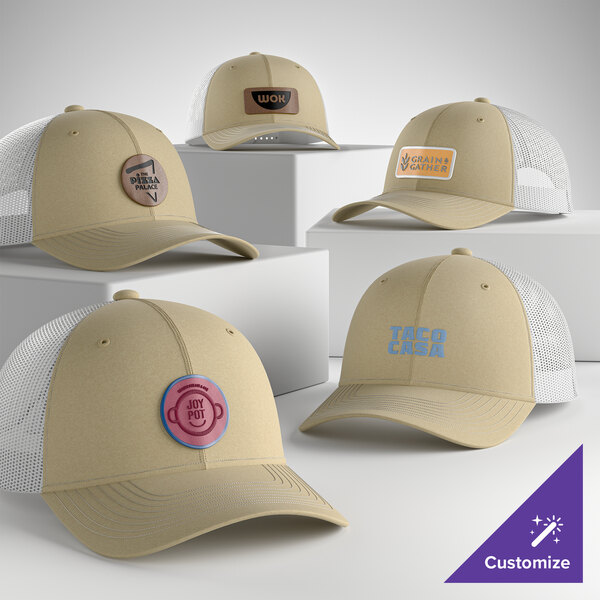 A group of light khaki and white mesh trucker caps with various custom logos displayed on a white background.