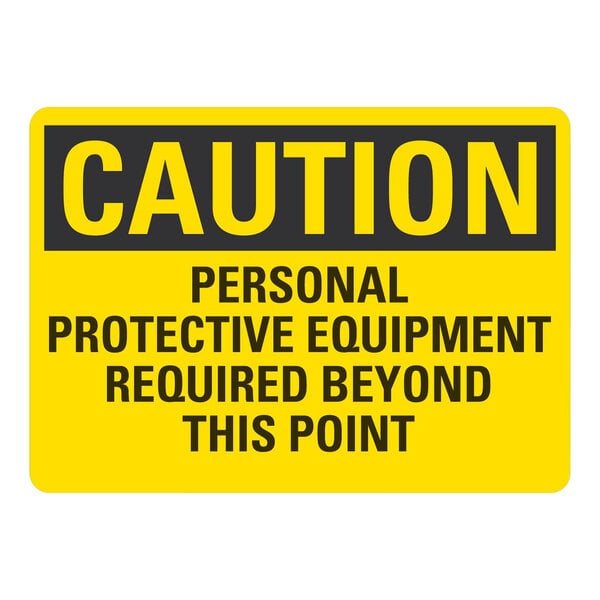 A yellow and black non-reflective plastic safety sign that says "Caution / Personal Protective Equipment Required Beyond This Point"