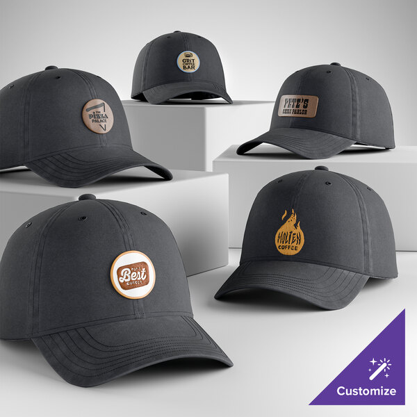 A collection of customizable dark gray unstructured, low-profile 6-panel dad caps with various logo patches on the front.