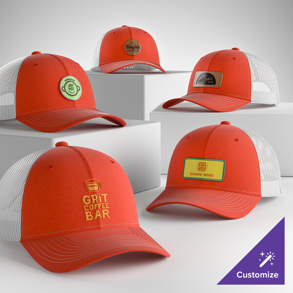 A collection of customizable orange and white 6-panel trucker caps with mesh backs, featuring various logo designs on the front.
