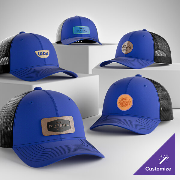 A collection of customizable blue and black mesh trucker caps with various logo patches on the front.