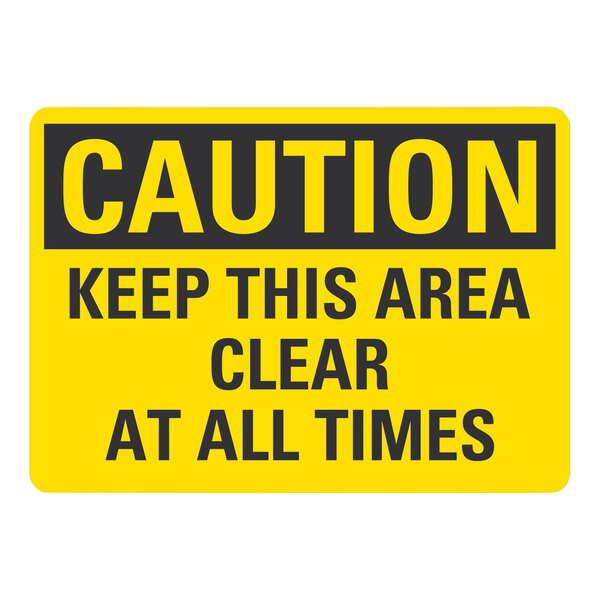 A yellow and black Lavex adhesive vinyl safety label that says "Caution / Keep This Area Clear At All Times"