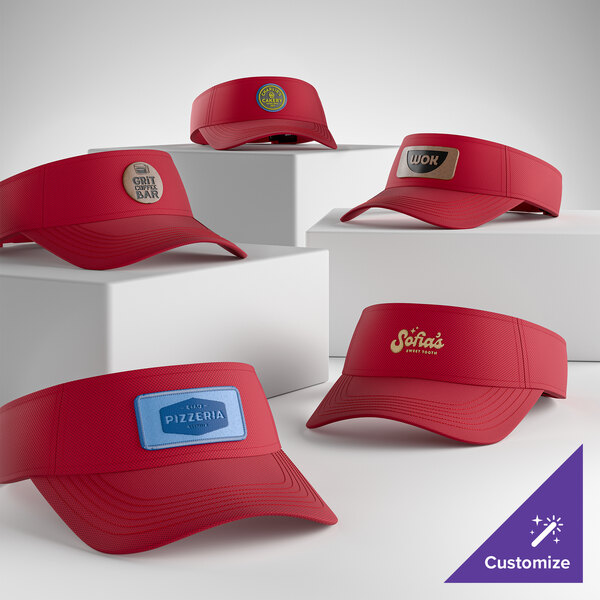 A collection of customizable red Sport-Tek STC51 moisture-wicking visors displayed on white blocks.