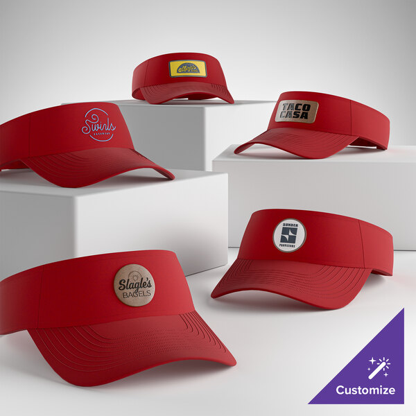 A collection of customizable red visors with various logo designs displayed on the front.