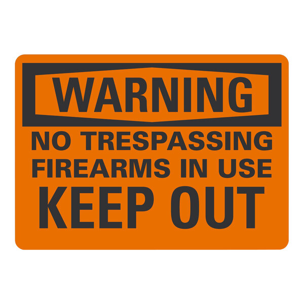 A white rectangular aluminum sign with black and orange text that reads "Warning / No Trespassing / Firearms In Use / Keep Out"