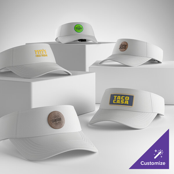 A collection of white moisture-wicking visors with customizable logos displayed on a white background.