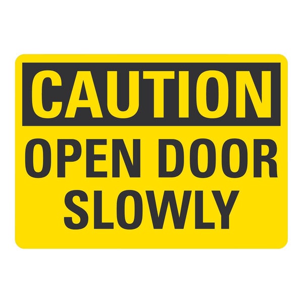 A yellow non-reflective aluminum "Caution / Open Door Slowly" safety sign with black text.