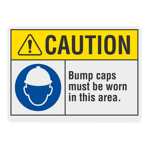A blue and white rectangular sign that says "Caution / Bump Caps Must Be Worn In This Area"