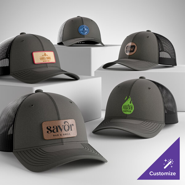 A collection of customizable grey steel and black 6-panel trucker caps with mesh backs and various logo patches.