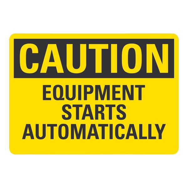 A yellow sign with black text that says "Caution / Equipment Starts Automatically" on a white background.