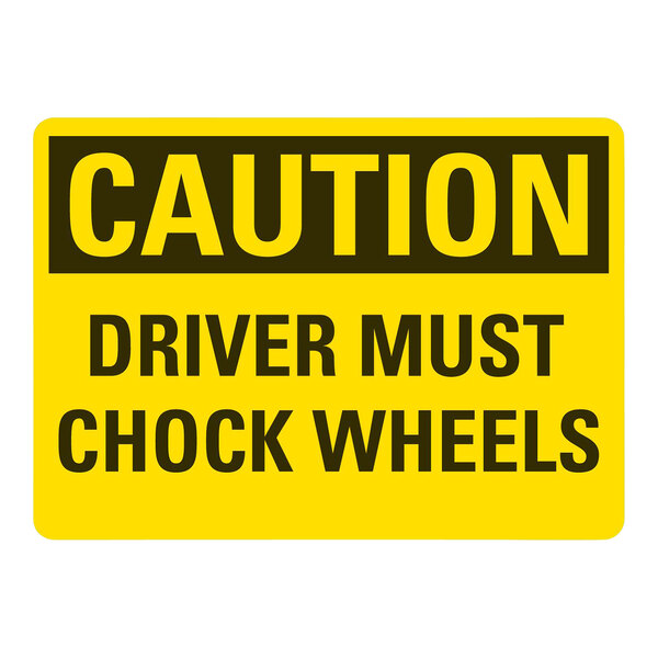 A yellow rectangular safety label with black text reading "Caution Driver Must Chock Wheels" on a white background.