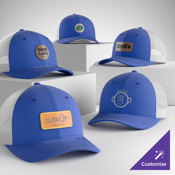 A collection of customizable blue and white mesh-back trucker caps with various logo patches displayed on the front panels.