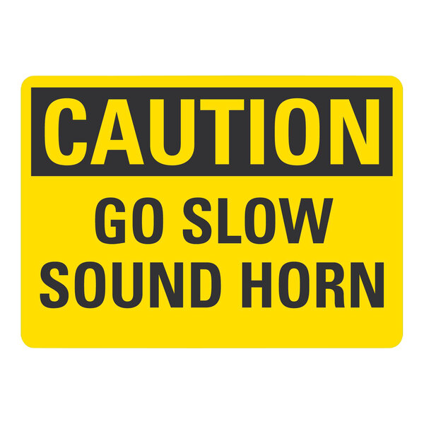 A yellow Lavex aluminum safety sign with black text that says "Caution Go Slow Sound Horn"