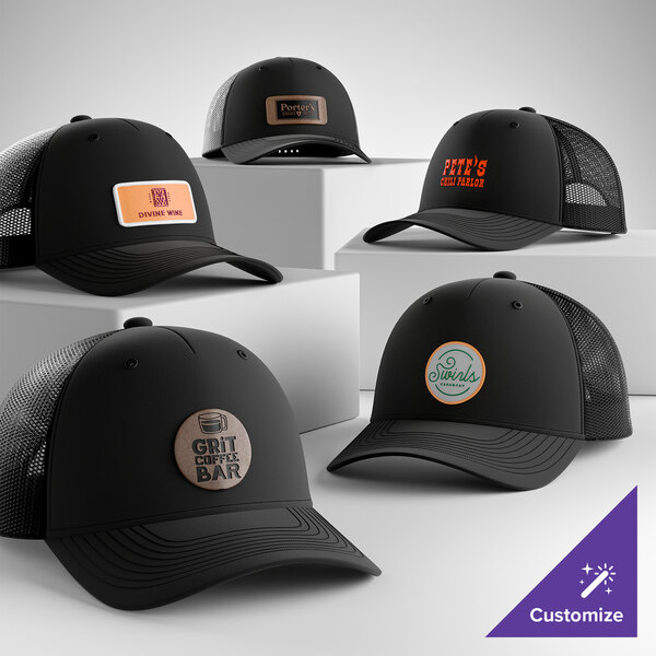 A collection of customizable black 5-panel trucker caps with mesh backs and various logo patches on the front.