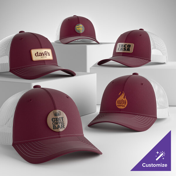 A collection of customizable maroon and white 6-panel trucker caps with mesh backs and various logo designs.