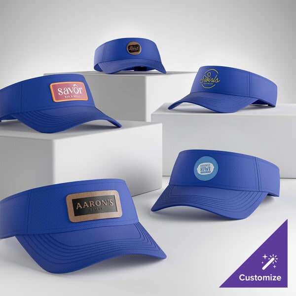 A collection of customizable royal blue moisture-wicking visors displayed on white blocks.