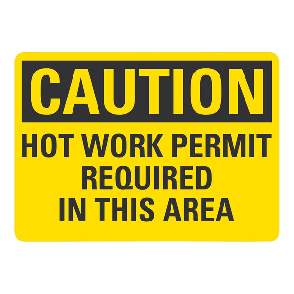 A yellow sign with black text that says "Caution / Hot Work Permit Required In This Area" in black letters.