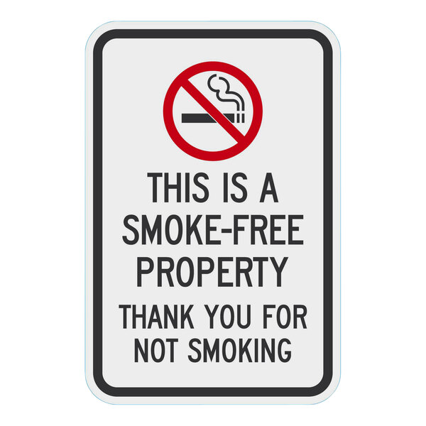 A white rectangular sign with black text that says "This Is A Smoke-Free Property / Thank You For Not Smoking" on it.