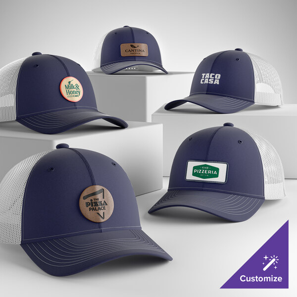 A collection of customizable true navy and white 6-panel trucker caps with mesh backs, featuring various logo designs on the front.