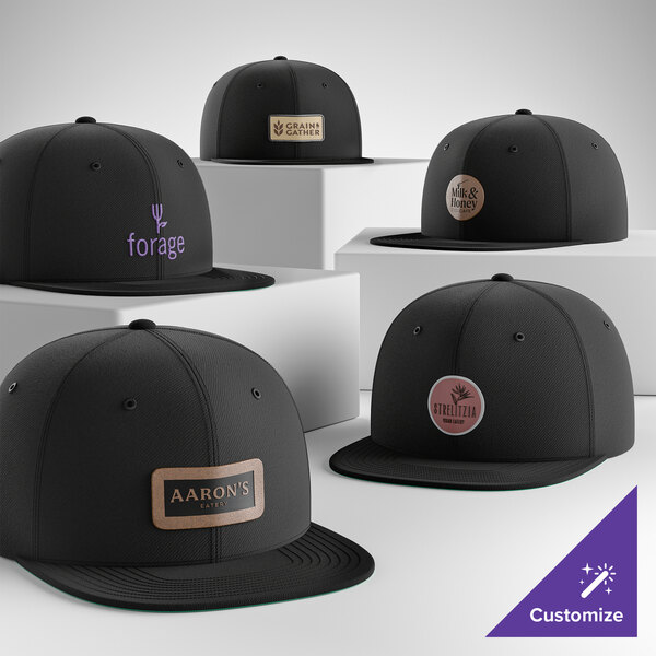 A collection of customizable black 6-panel flat bill snapback caps with various logo designs on the front.