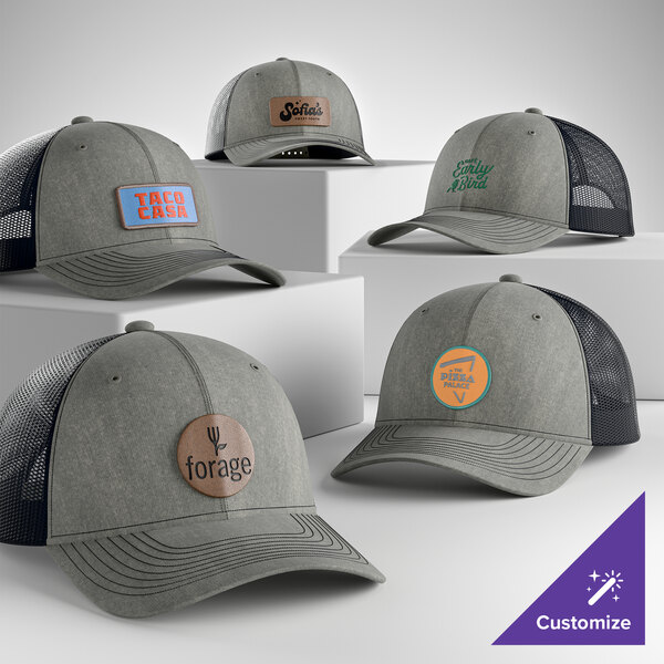 A collection of customizable heather grey and navy 6-panel trucker caps with mesh backs and various logo designs.