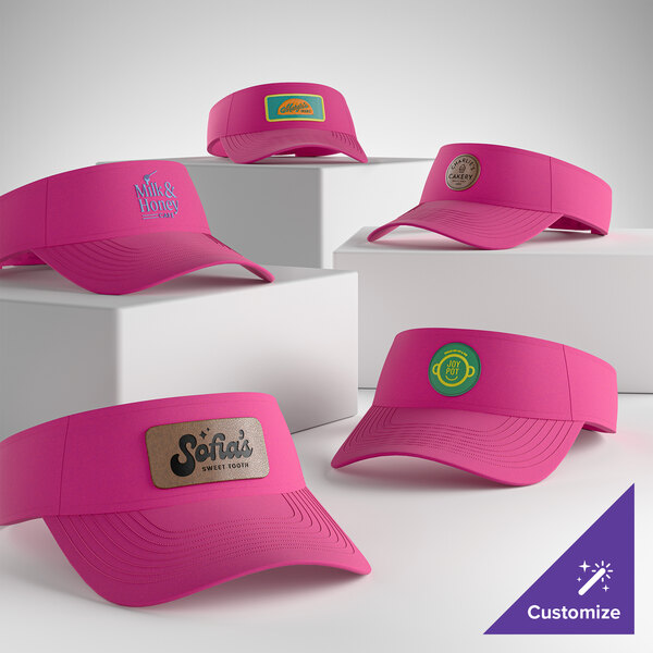 A collection of customizable sangria pink visors displayed on white blocks.
