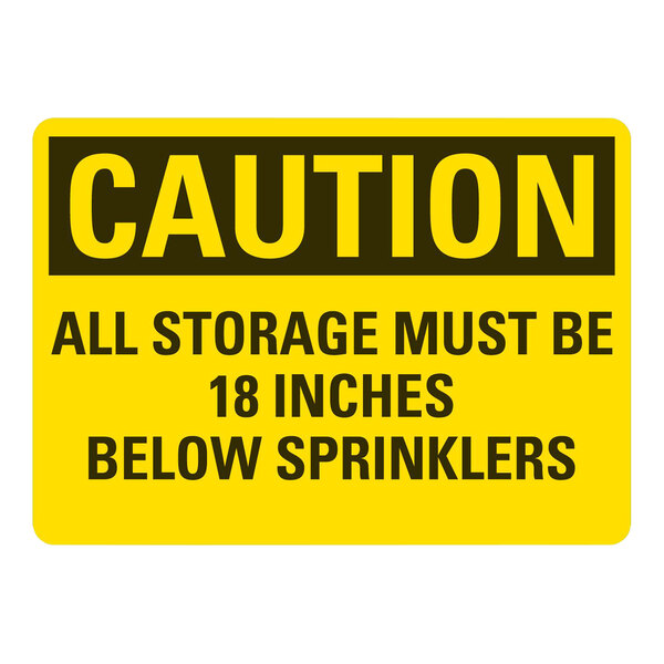 A yellow and black rectangular plastic sign with white text that reads "Caution / All Storage Must Be 18 Inches Below Sprinklers"