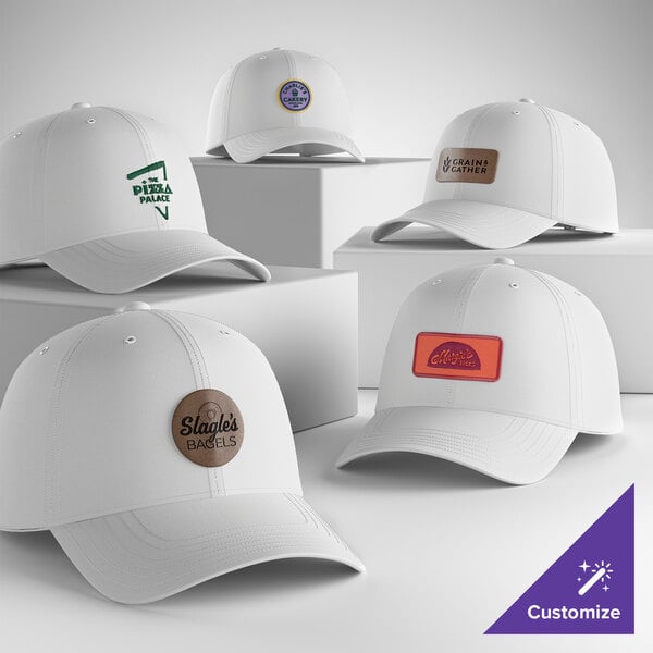A collection of customizable white 6-panel dad caps with various logo patches displayed on the front.
