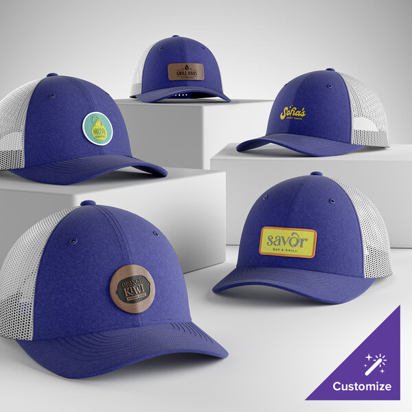 A group of customizable heather royal and white 6-panel trucker caps with mesh backs and various logo patches displayed on the front.