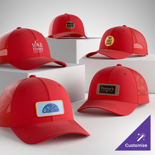 A collection of customizable true red 6-panel trucker caps with mesh backs, featuring various logo designs on the front.