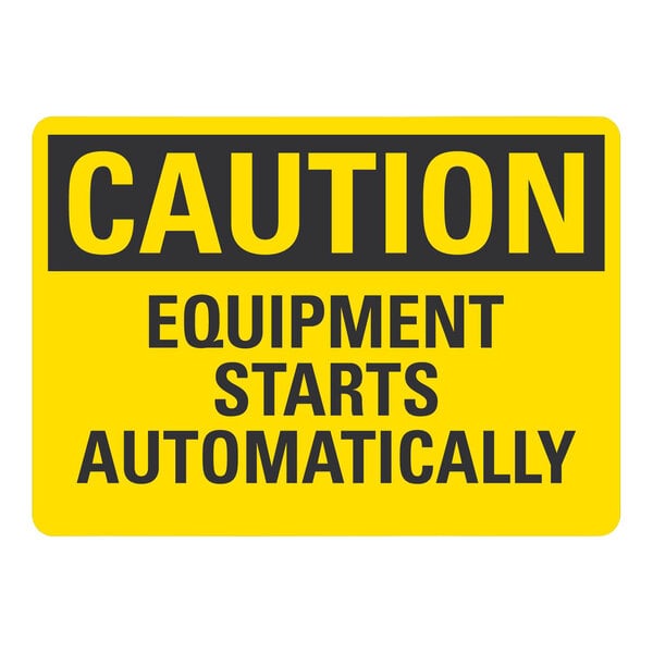 A yellow sign with black text reading "Caution Equipment Starts Automatically" on a white background.