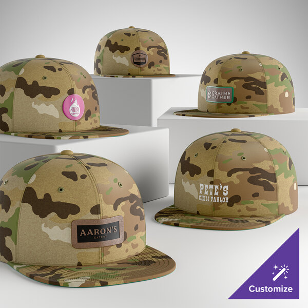 A collection of customizable MultiCam camouflage flat bill snapback caps with various logo designs displayed on the front panels.