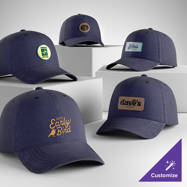 A collection of customizable navy blue denim 6-panel unstructured dad caps with various logo designs on the front.