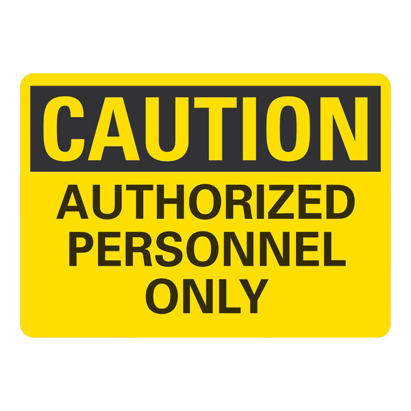 A yellow sign with black text that says "Caution / Authorized Personnel Only" on a white background.