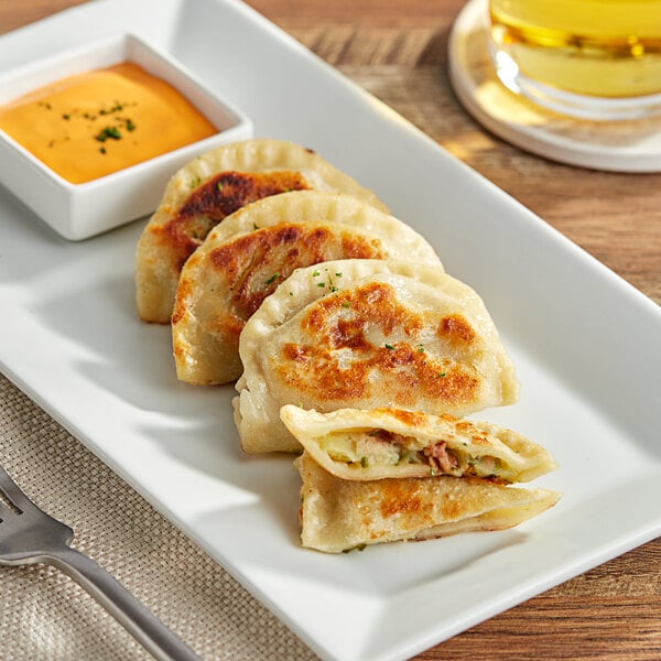 A plate of Jaju Loaded Baked Potato Pierogies with a fork.